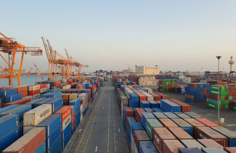 Cargo containers at a busy port at sunrise